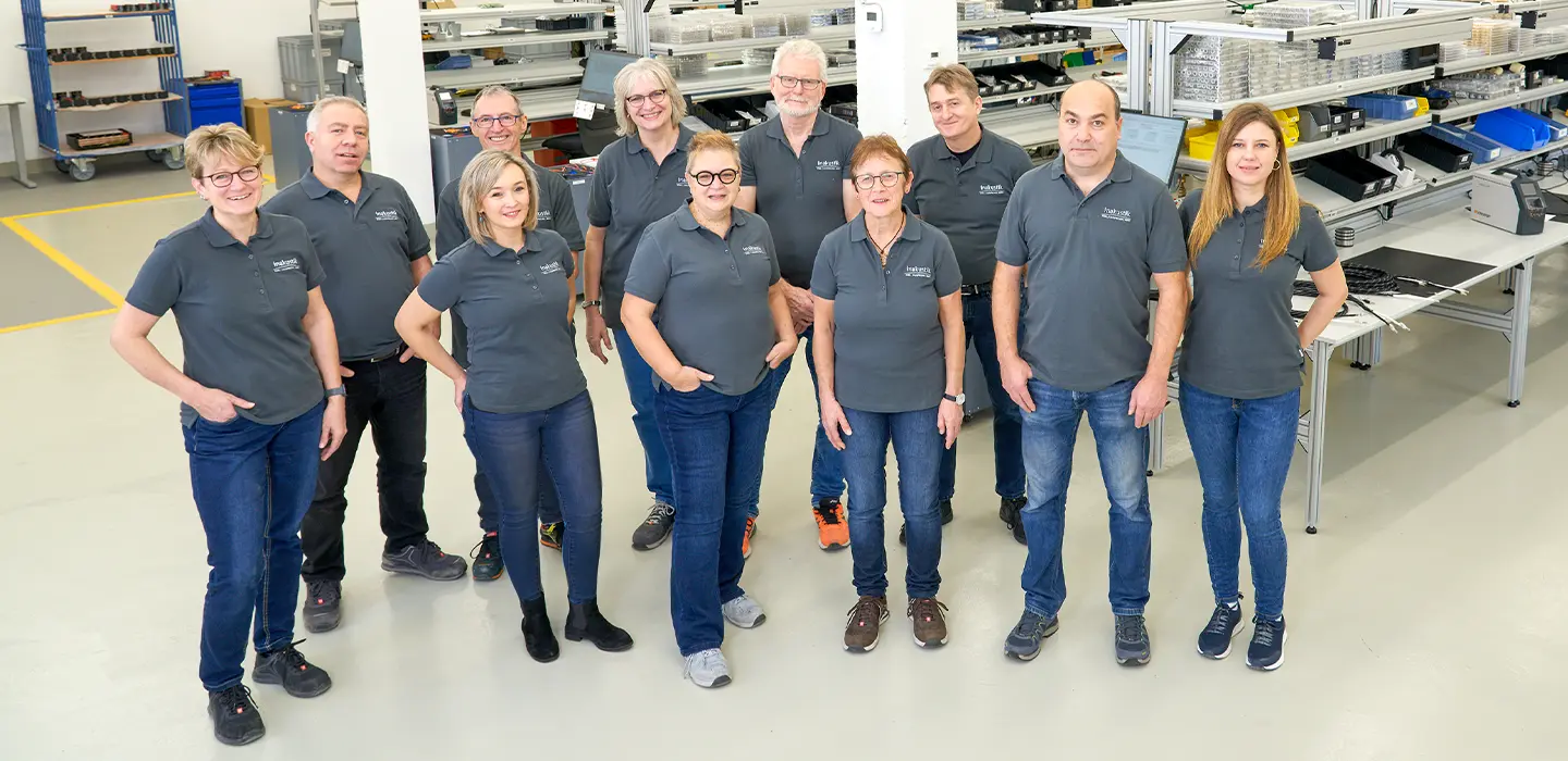in-akustik Team in grauen Poloshirts in Werkstatt
